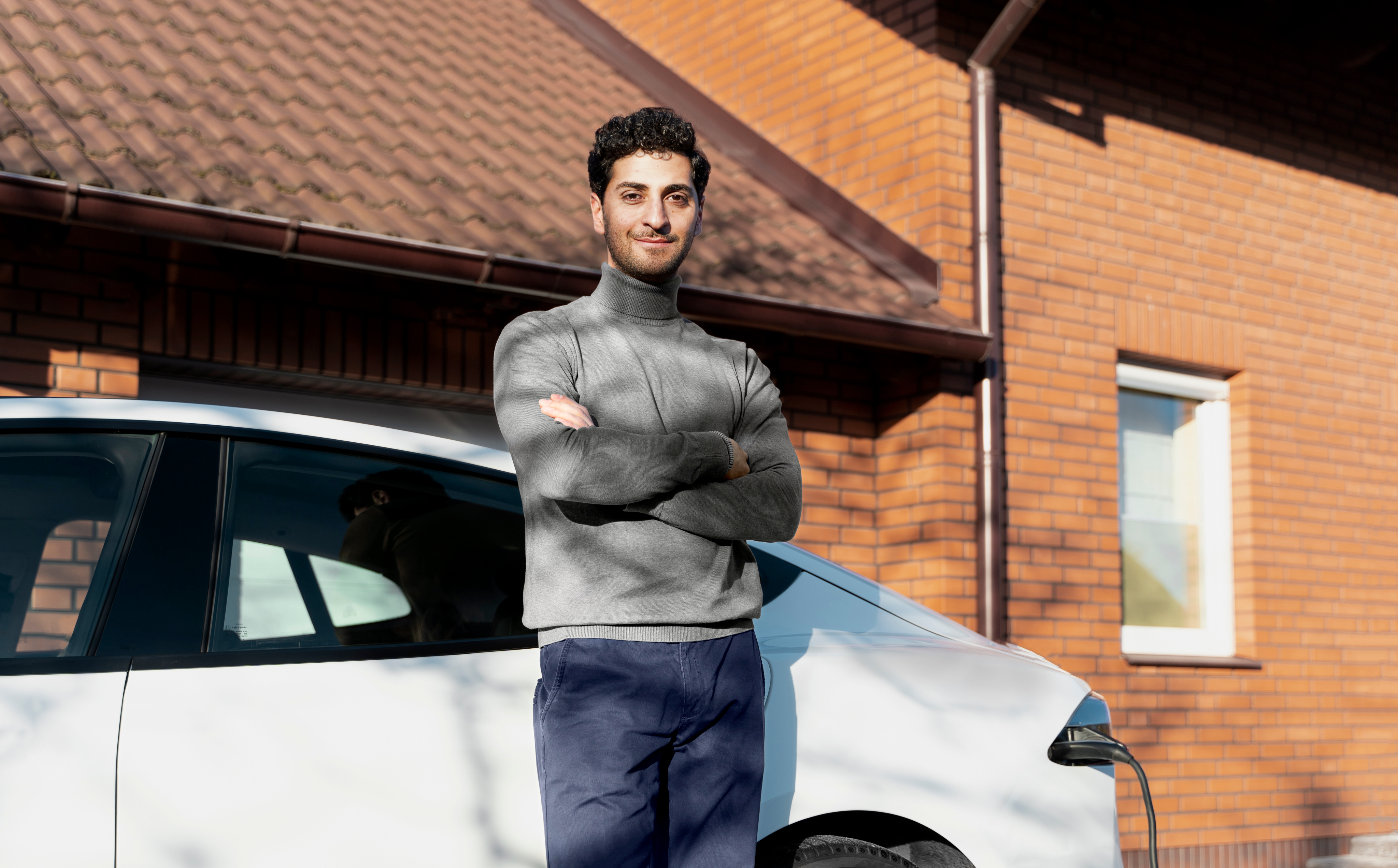 Pessoa ao lado do automóvel em frente à casa
